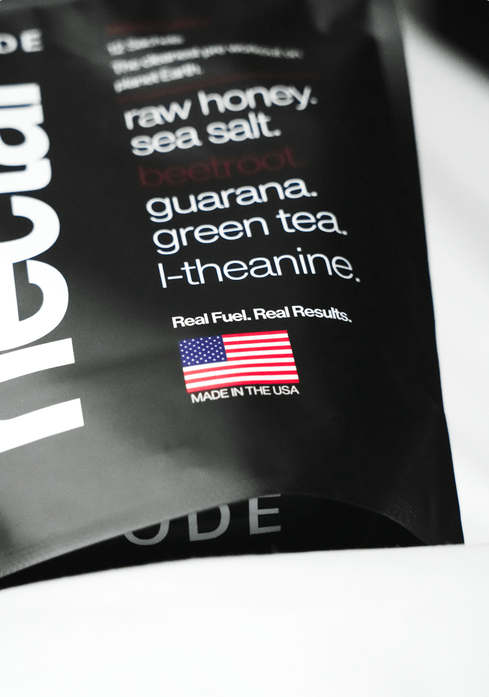 Black package with white text listing ingredients and an American flag, on a white background.